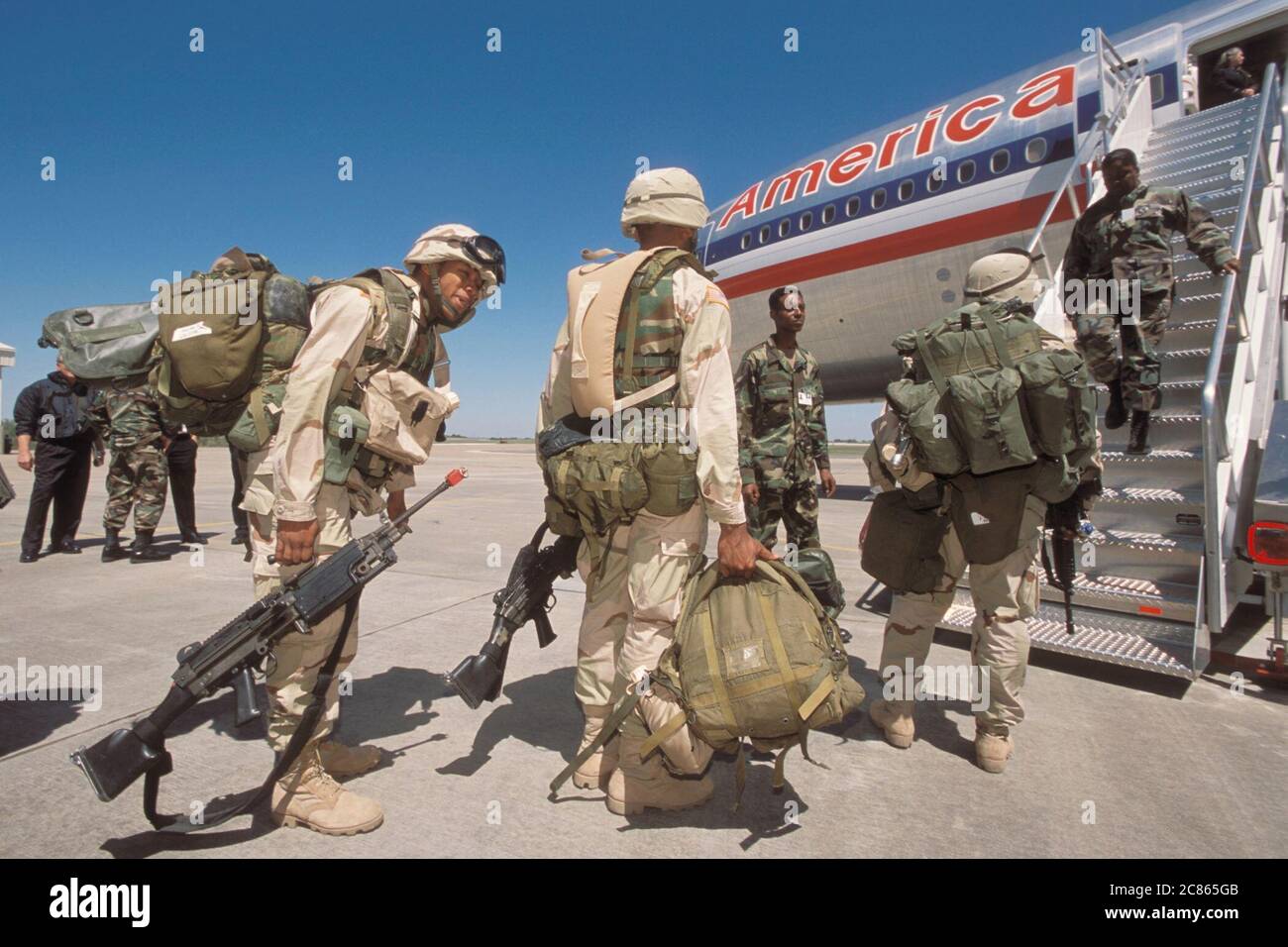 Fort Hood Army base, Texas USA, inverno 2003: Soldati che indossano uniformi mimetiche e trasportano le loro armi a bordo di un aereo commerciale mentre si schierano in Medio Oriente durante l'operazione Iraqi Freedom. ©Bob Daemmrich Foto Stock