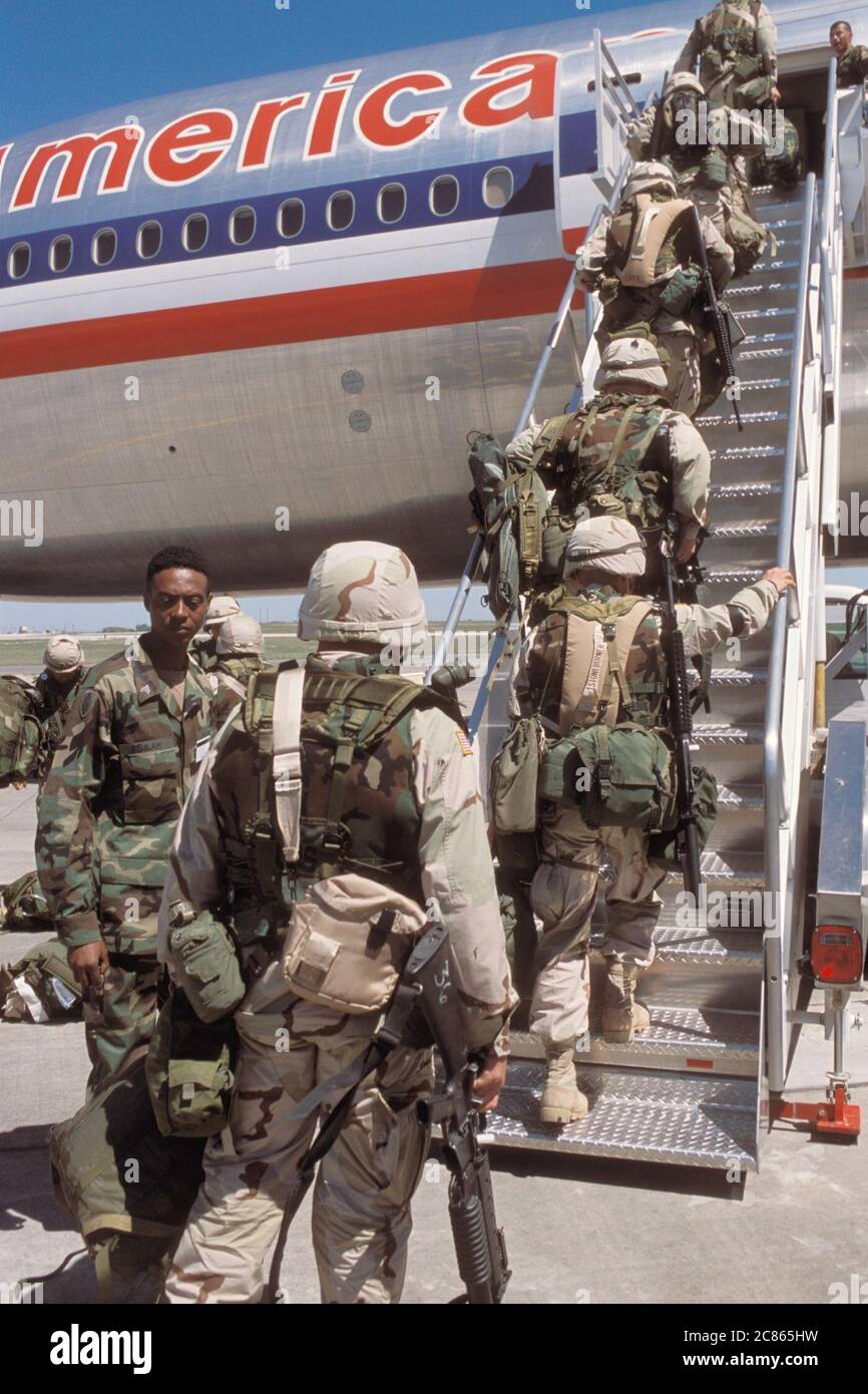 Fort Hood Army base, Texas USA, inverno 2003: Soldati che indossano uniformi mimetiche e trasportano le loro armi a bordo di un aereo commerciale mentre si schierano in Medio Oriente durante l'operazione Iraqi Freedom. ©Bob Daemmrich Foto Stock