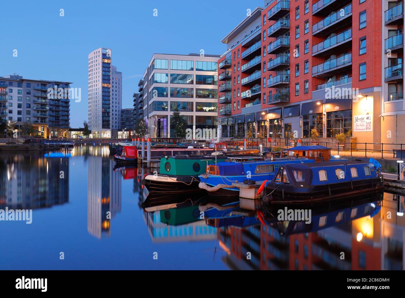 Riflessioni al Leeds Dock, che è stato sviluppato per uso misto nel centro di Leeds. Foto Stock