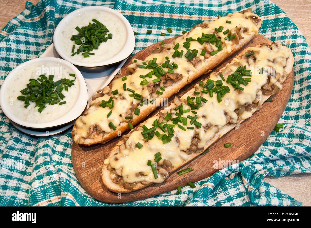 casseruola con formaggio e funghi cosparsa di erba cipollina fresca con salsa tzatziki Foto Stock