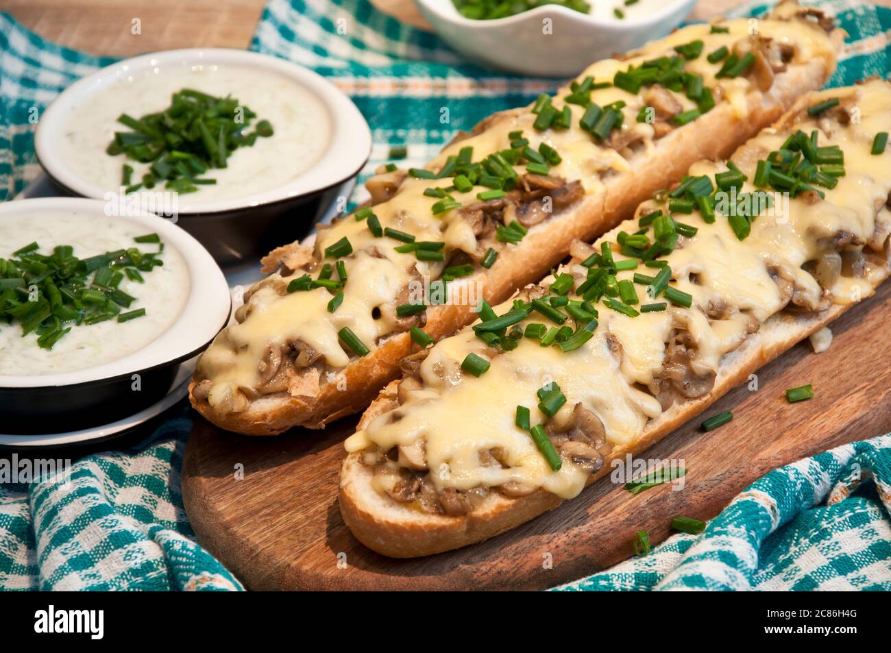 casseruola con formaggio e funghi cosparsa di erba cipollina fresca con salsa tzatziki Foto Stock