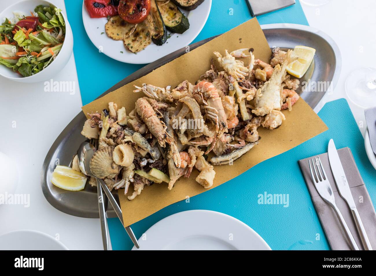 Delizioso piatto di pesce fritto per due in vacanza estiva nel tradizionale ristorante costale croato vicino al mare. Foto Stock