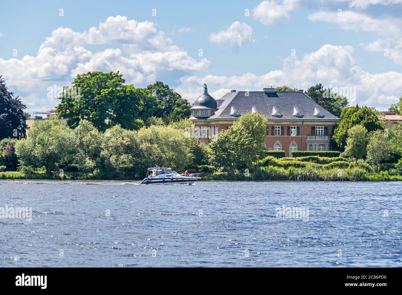 Potsdam, Germania - 12 luglio 2020: Lago di Glienicker con l'edificio di Villa Kampffmeyer e una famiglia sulla barca per il tempo libero Foto Stock