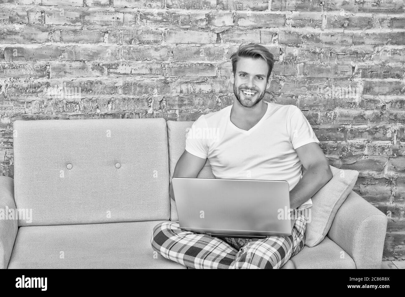 freelance che lavora da casa. lavoro a distanza durante la quarantena. bell'uomo che comunica con il laptop. utilizzare il notebook prima di dormire. blogger maschio utilizzare la tecnologia internet. rete sul computer. Foto Stock