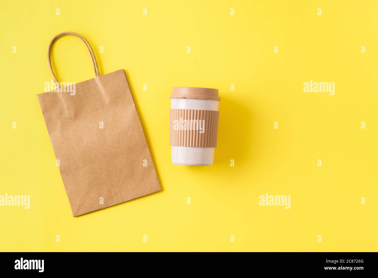 Tazza di cocata riutilizzabile in bambù sostenibile per viaggi e borsa di carta per kraft. Tazza di prelievo con tappo antigoccia. Concetto privo di plastica. Foto Stock