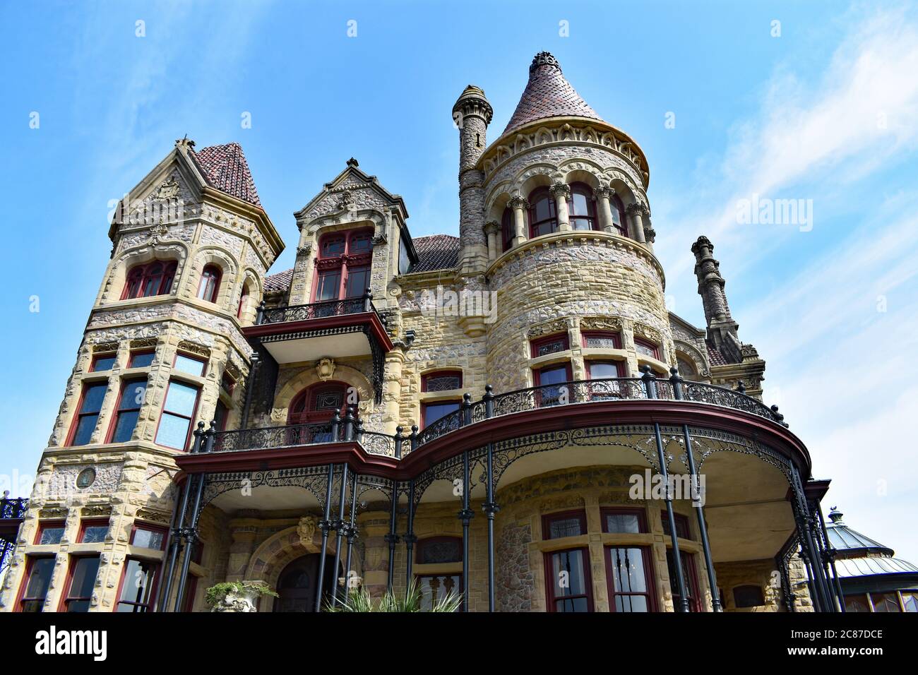 Guardando verso l'alto il palazzo episcopale 1892 in stile vittoriano a Galveston, Texas. Il palazzo crea un profilo drammatico contro un cielo azzurro. Foto Stock