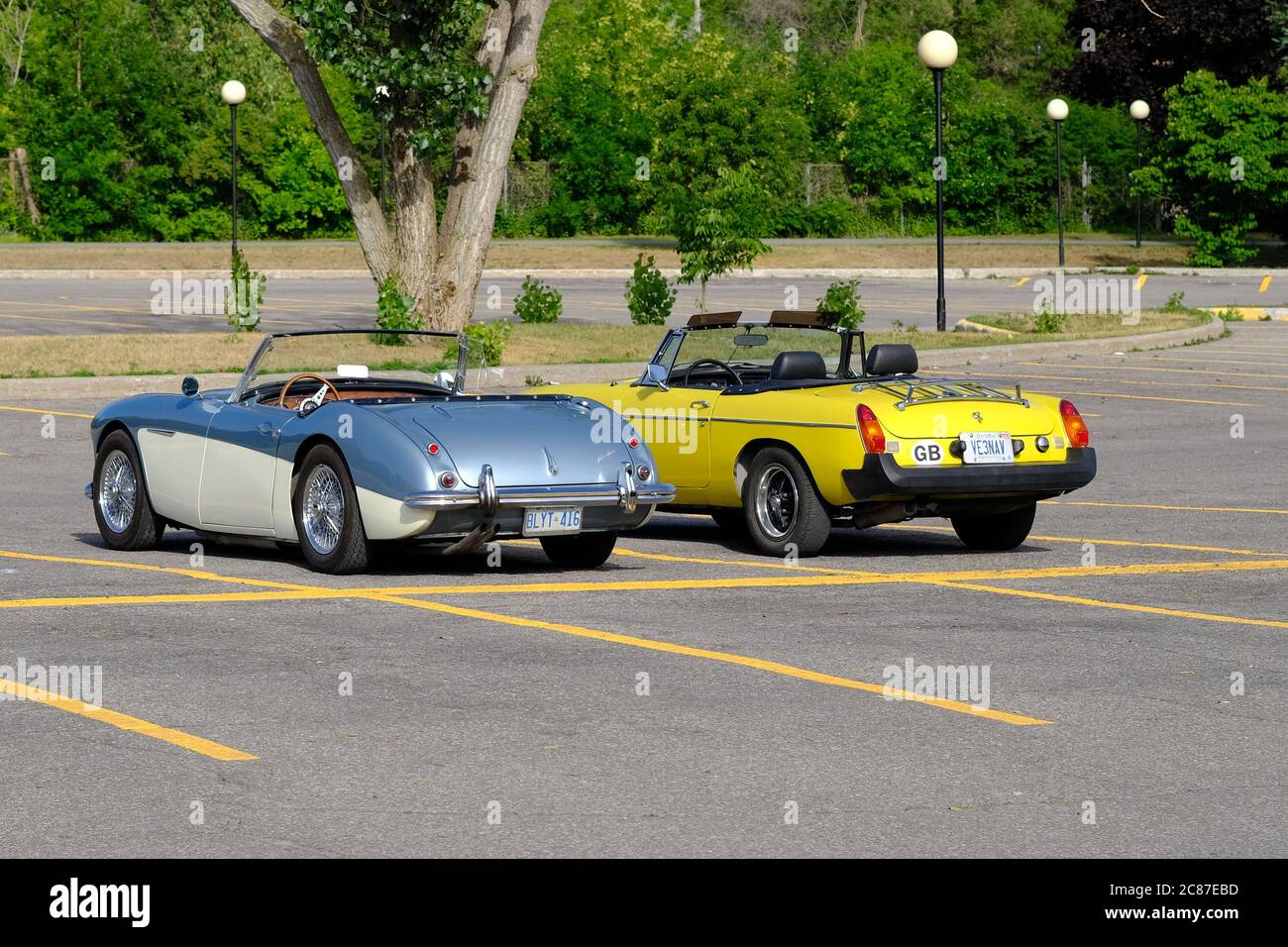 Un argento/beige Austin Healey 3000 e un GIALLO canarino MG MGB insieme in un parcheggio a Ottawa, Ontario, Canada. Foto Stock