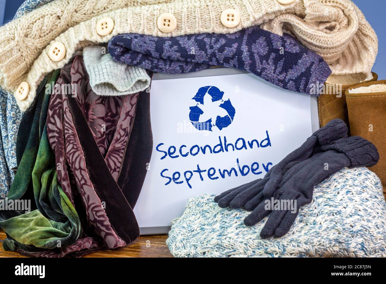Vestiti amati in una scatola contrassegnata con il cartello di seconda mano settembre riciclare i tessuti simbolo, riutilizzare i vestiti di riciclo scambiando per fash sostenibile Foto Stock