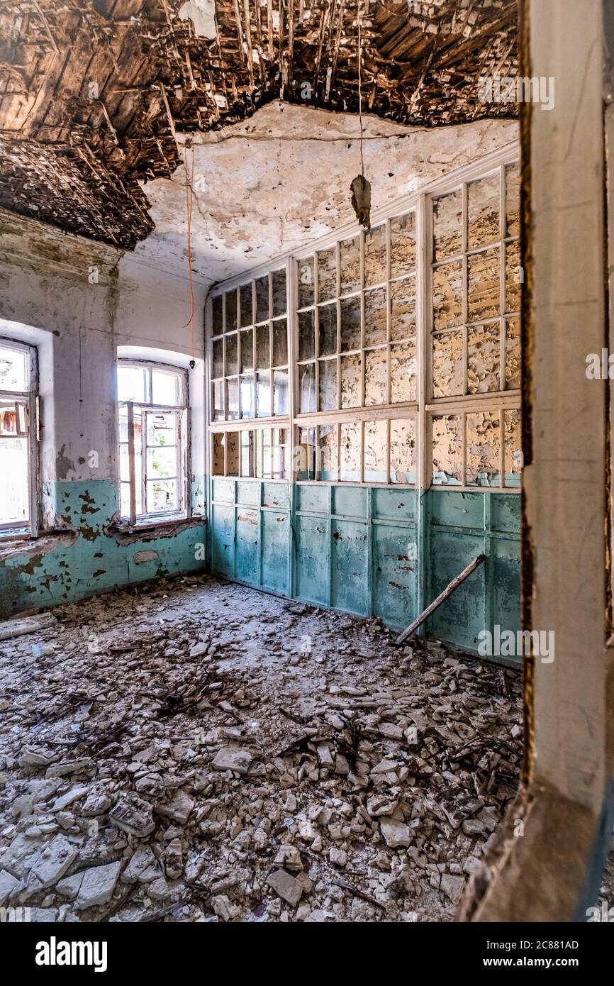 stanza abbandonata ospedale di colore azzurro con molte finestre Foto Stock