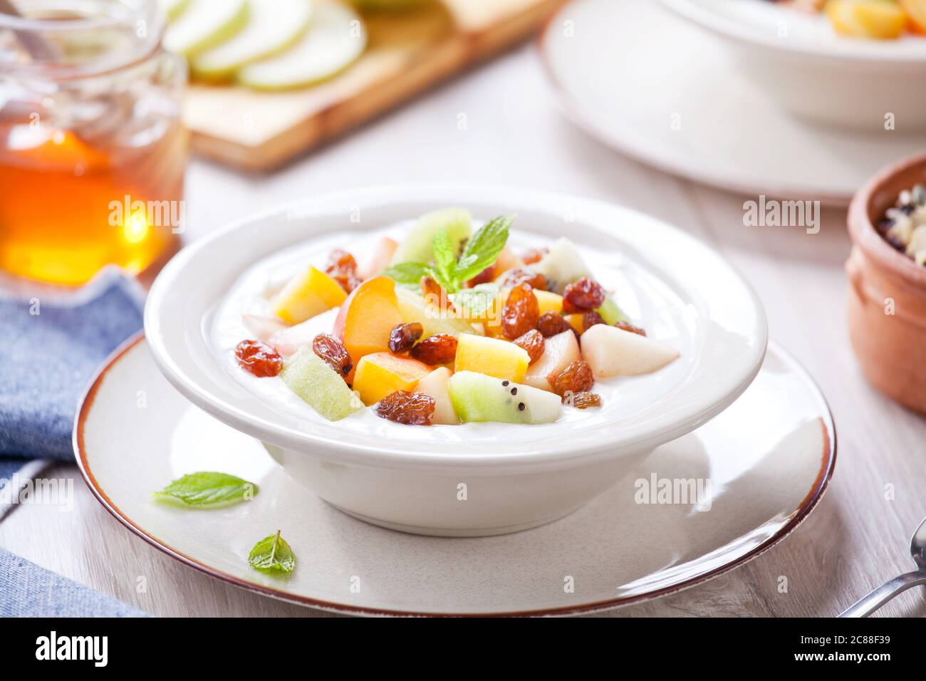 Ciotola di yogurt greco fresco con un mazzo di frutta organica Foto Stock