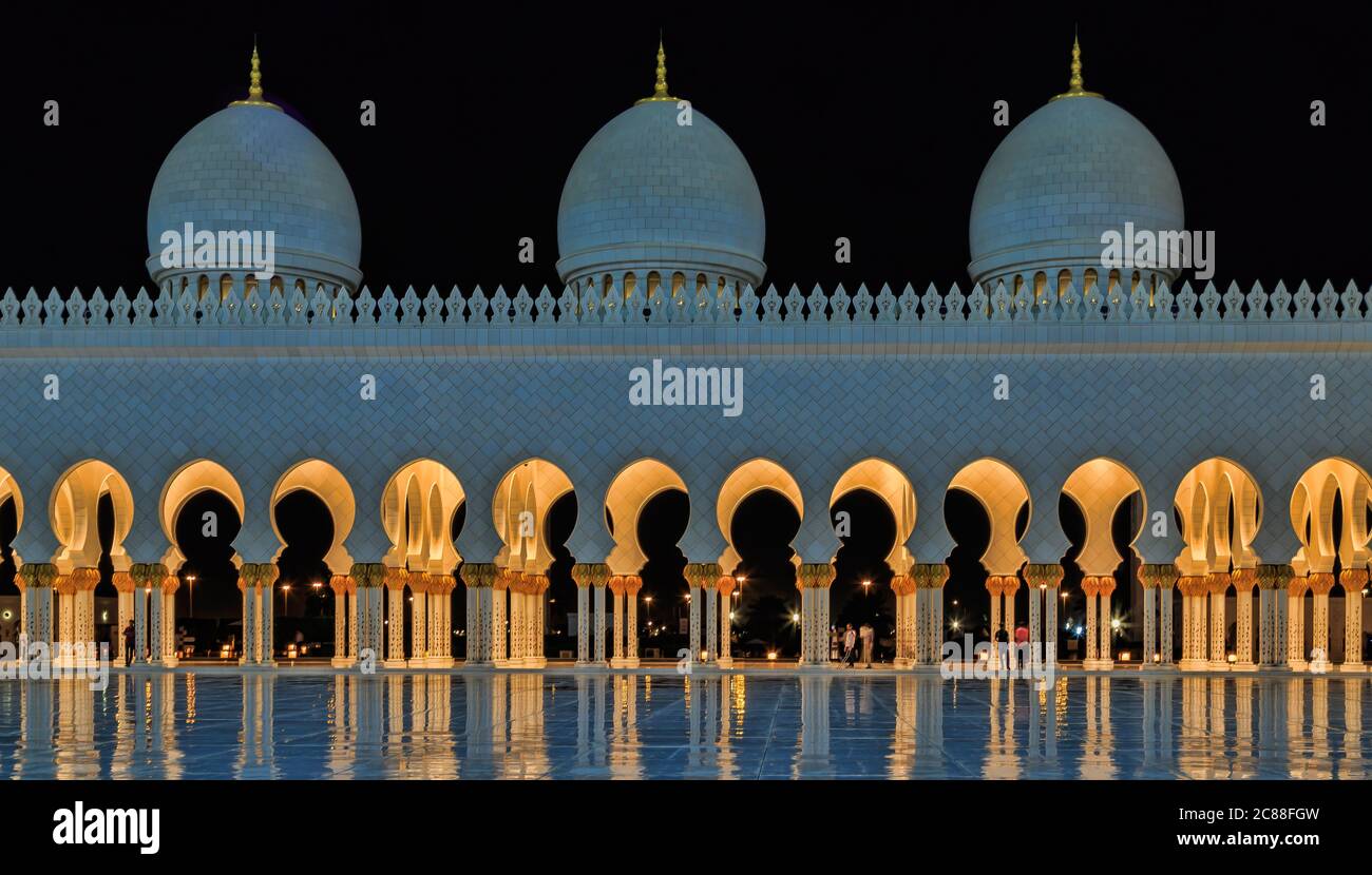 La Grande Moschea dello Sceicco Zayed, Abu Dhabi di notte con riflessione in acqua Foto Stock