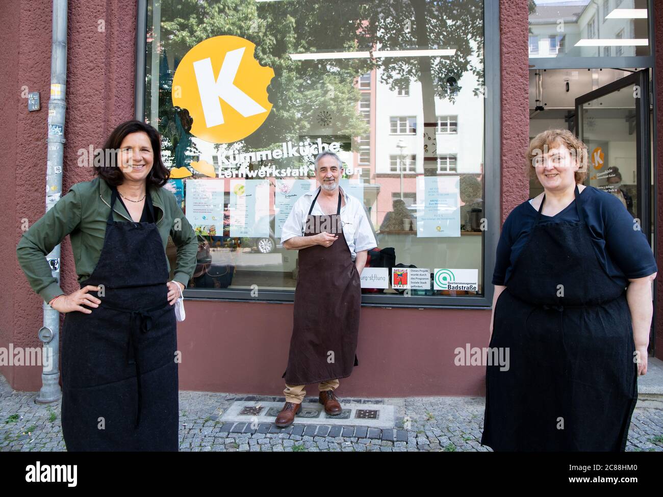 22 luglio 2020, Berlino: Katrin Göring-Eckardt (l), presidente della fazione Bundestag di Bündnis 90/Die Grünen, partecipa alla cucina per i bisognosi della Fondazione Lichtburg. Insieme a Yusuf Beyazit (M) e Regina Bludau (r), lo stufato di fagioli di cavolo di savoia è stato cotto con il bulgur. Ogni mercoledì, circa 200 pasti vengono preparati nella cucina a scomparsa e distribuiti gratuitamente ai bisognosi dai partner della cooperazione. La cucina a vista appartiene al microcosmo Gartenstadt Atlantic, un progetto tedesco-ebraico-musulmano e interculturale. Foto: Bernd von Jutrczenka/dpa Foto Stock