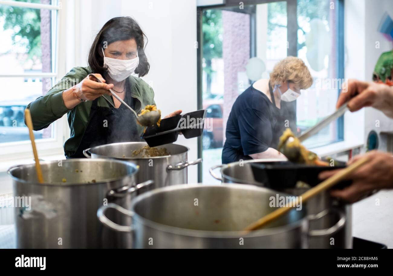 Berlino, Germania. 22 luglio 2020. Katrin Göring-Eckardt (l), presidente del gruppo parlamentare Bündnis 90/Die Grünen, partecipa alla "cucina per i bisognosi" nella cucina a carovana della Fondazione Lichtburg e distribuisce lo stufato di cavolo sabaudo in scatole a porzioni. Ogni mercoledì, circa 200 pasti vengono preparati nella cucina a scomparsa e distribuiti gratuitamente ai bisognosi dai partner della cooperazione. La cucina a vista appartiene al microcosmo Gartenstadt Atlantic, un progetto tedesco-ebraico-musulmano e interculturale. Credit: Bernd von Jutrczenka/dpa/Alamy Live News Foto Stock