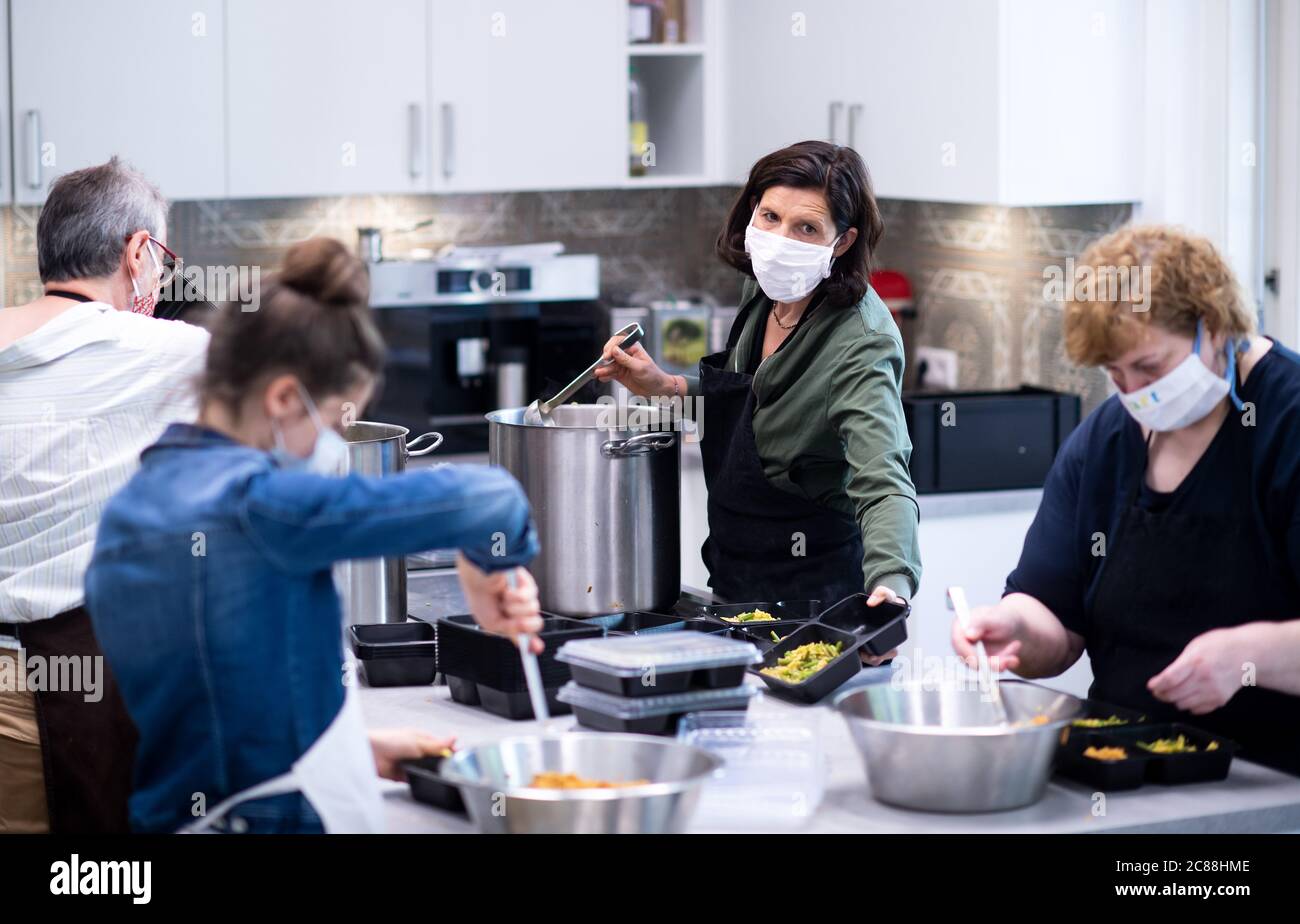 22 luglio 2020, Berlino: Katrin Göring-Eckardt (2° da destra), presidente della fazione Bundestag di Bündnis 90/Die Grünen, partecipa alla "cucina per i bisognosi" nella cucina di ritiro della Fondazione Lichtburg. Insieme a Yusuf Beyazit (l), Charlotte (2 da sinistra) e Regina Bludau, furono cucinati cavolo e fagiolo di Savoia con il bulgur. Ogni mercoledì, circa 200 pasti vengono preparati nella cucina a scomparsa e distribuiti gratuitamente ai bisognosi dai partner della cooperazione. La cucina a vista appartiene al microcosmo Gartenstadt Atlantic, un progetto tedesco-ebraico-musulmano e interculturale. Foto Foto Stock