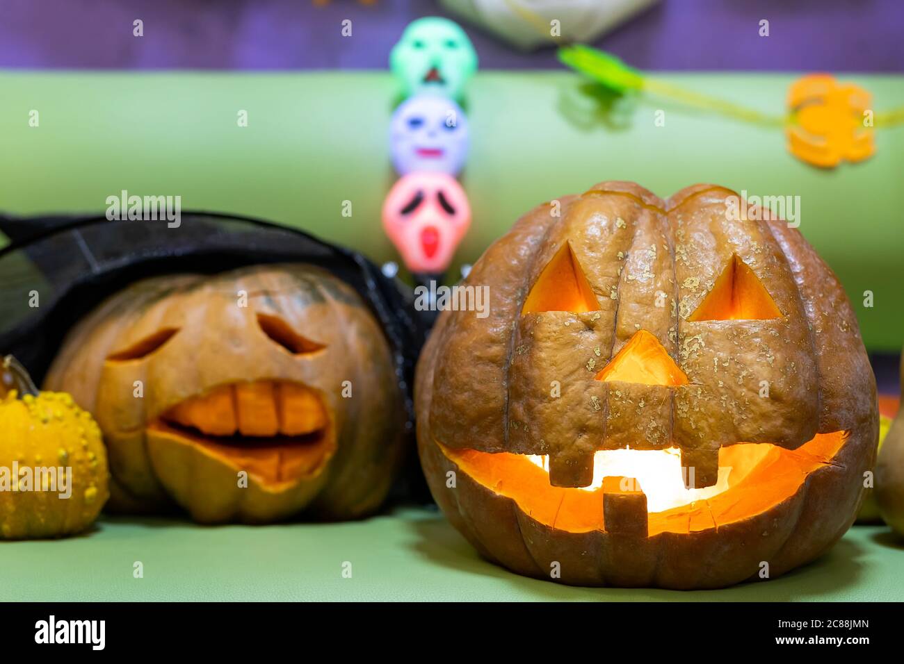 Testa di zucca arancione personalizzata e spoky, con volti intagliati e una candela o una luce incandescente all'interno. Halloween festa decorazione per celebrare Foto Stock