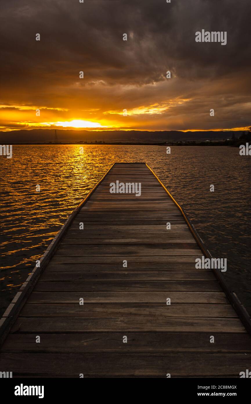 Vista del tramonto lungo un molo in legno sul lato occidentale del porto di Port Pirie, nell'Australia Meridionale. Foto Stock