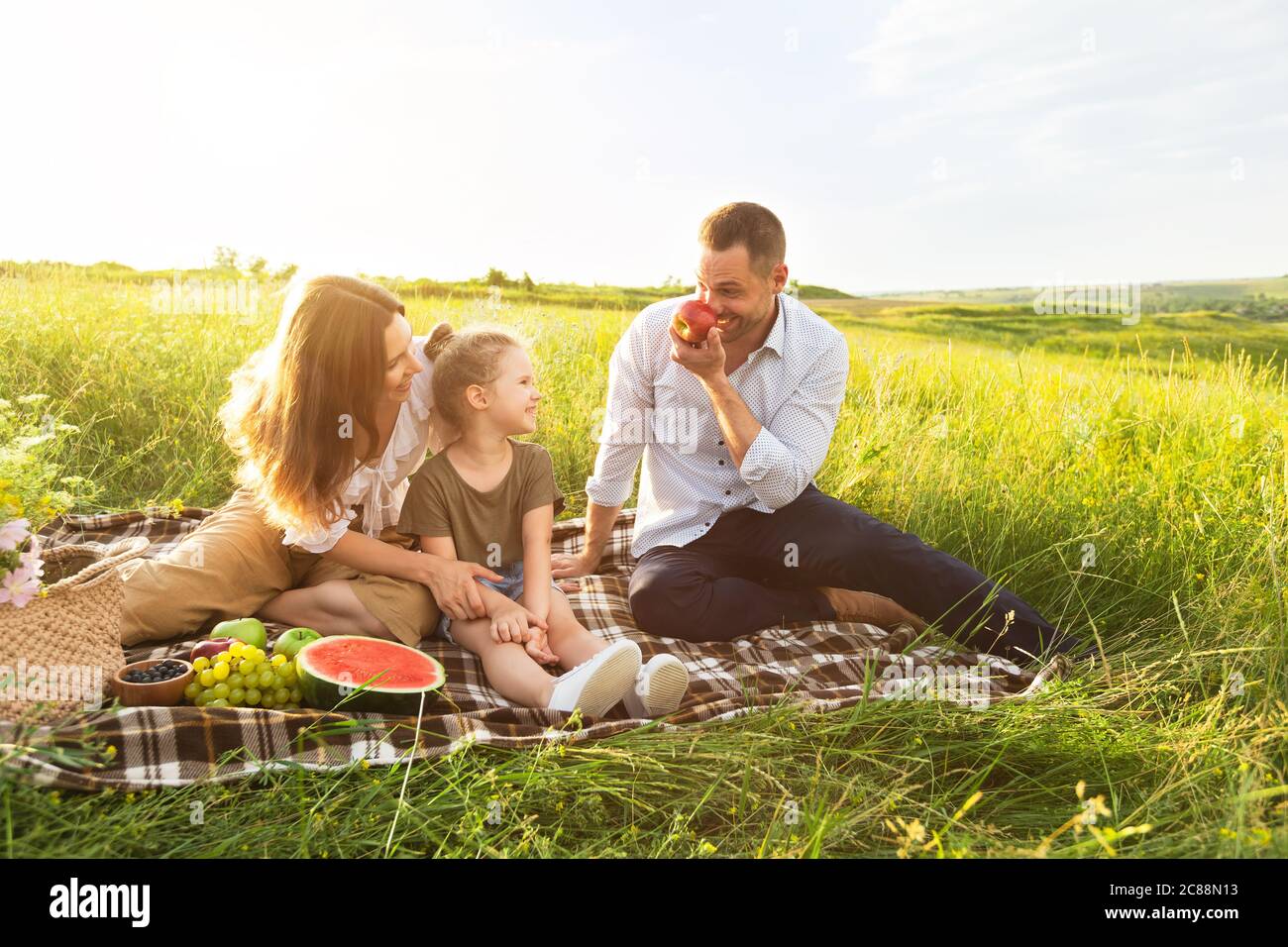 Buona famiglia che gioca con frutta in un picnic all'aperto Foto Stock