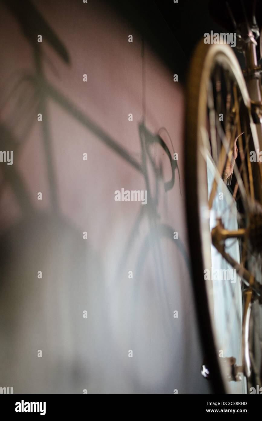 Fuoco selettivo di un'ombra di una vecchia bicicletta su una parete Foto Stock