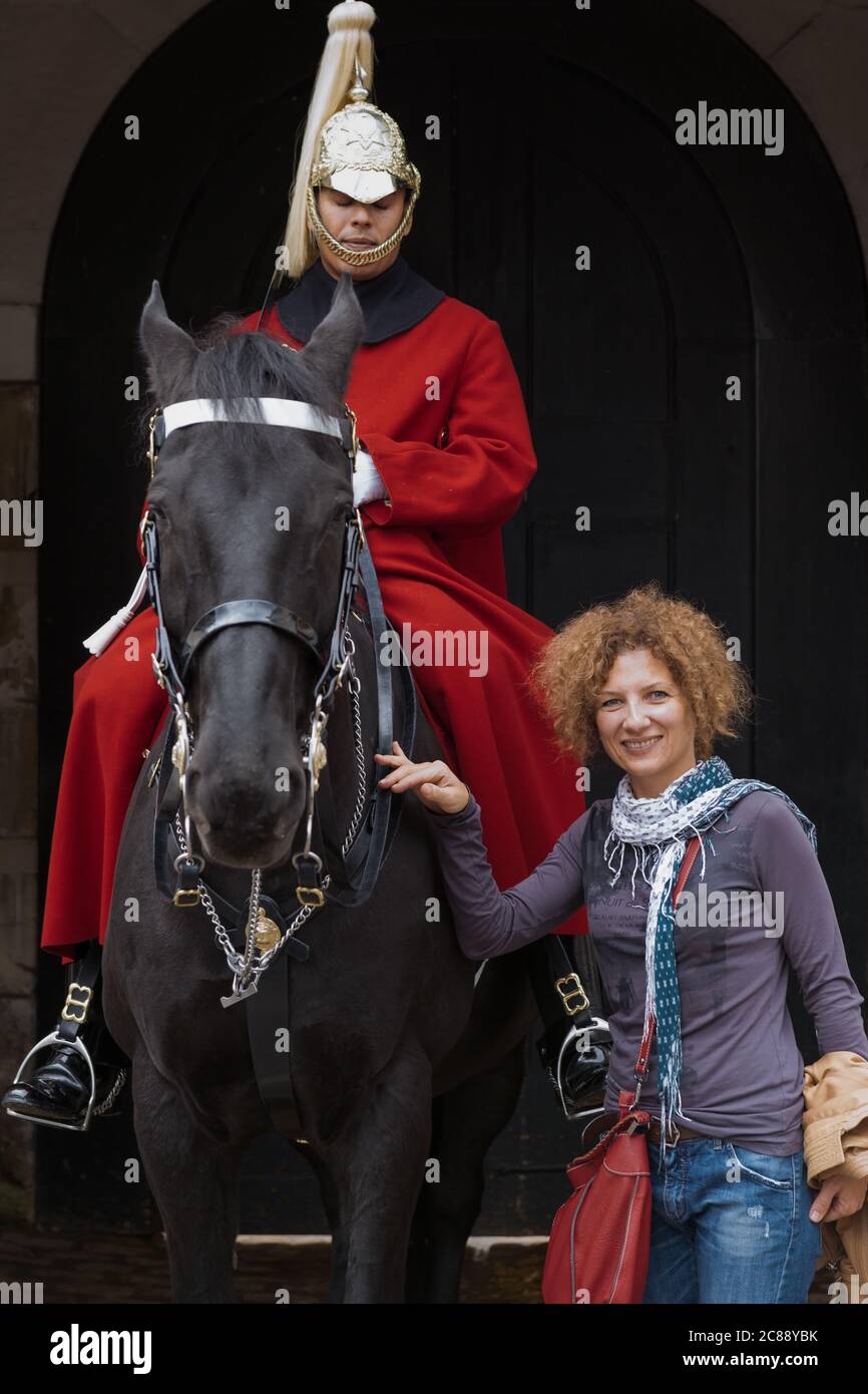 Giovane donna turistica femminile che posa per foto da una guardia di cavalli alla Whitehall Horse Guards a Londra UK nel 2013 Foto Stock