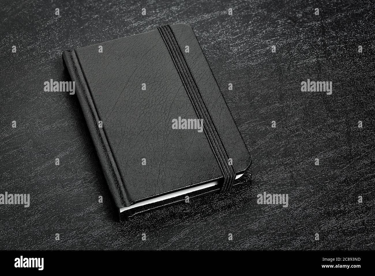 libro di agenda in pelle nera su superficie nera Foto Stock