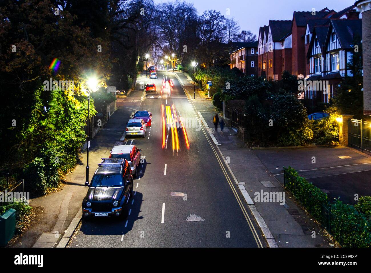 Una vista notturna di Stanhope Road dal ponte sulla Parkland Walk, auto e altri percorsi di traffico lasciando luce, Londra, Regno Unito Foto Stock