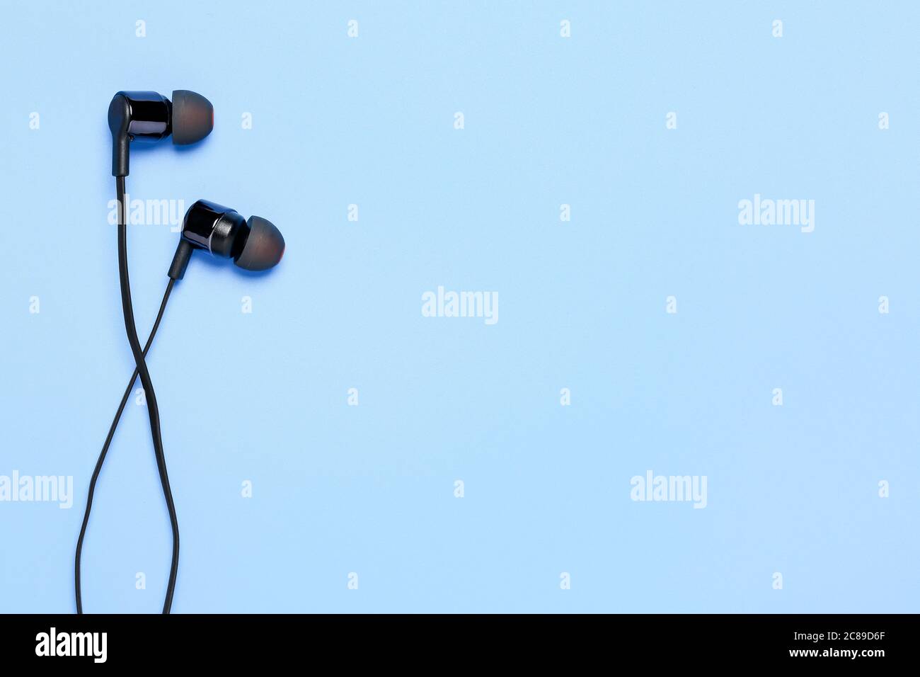 auricolari moderni su superficie ciano con spazio per la copia Foto Stock