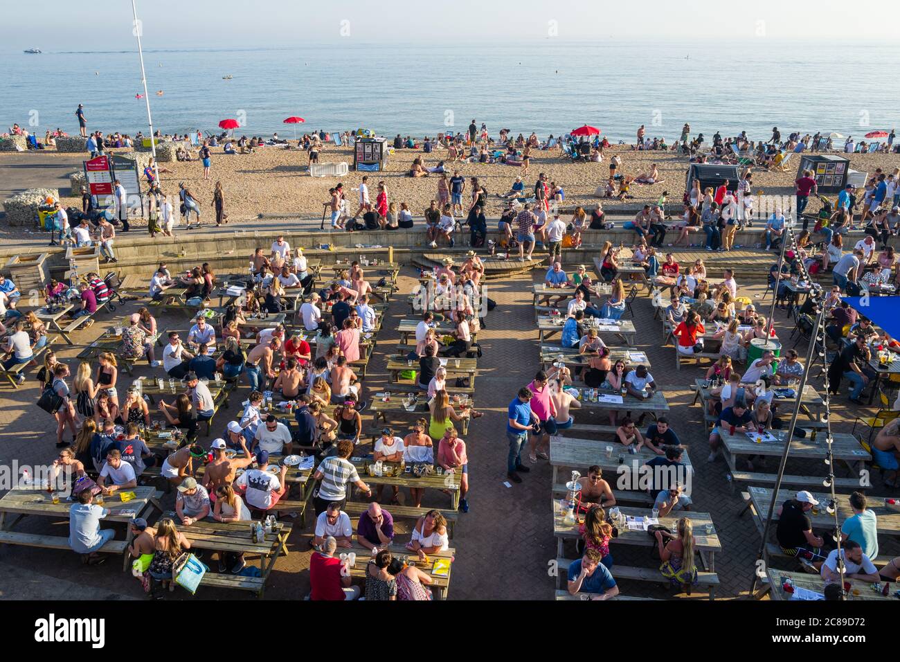 Persone che hanno un buon tempo a bere fuori sulla spiaggia di Brighton Regno Unito in pre-Covid Times Foto Stock