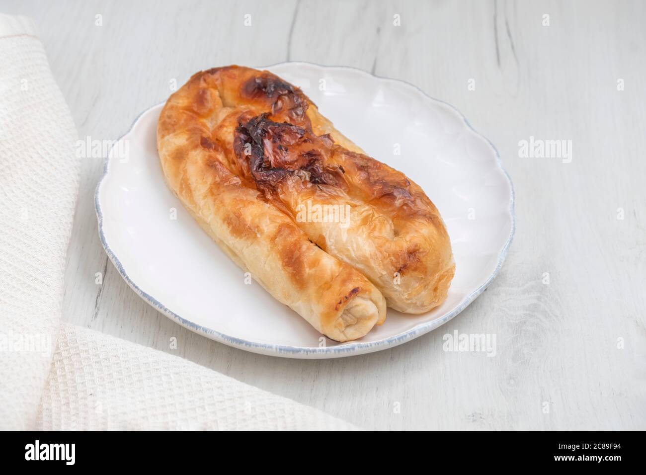 Saporito formaggio bulgaro pasticceria banitsa (Banitza) su sfondo bianco di legno Foto Stock