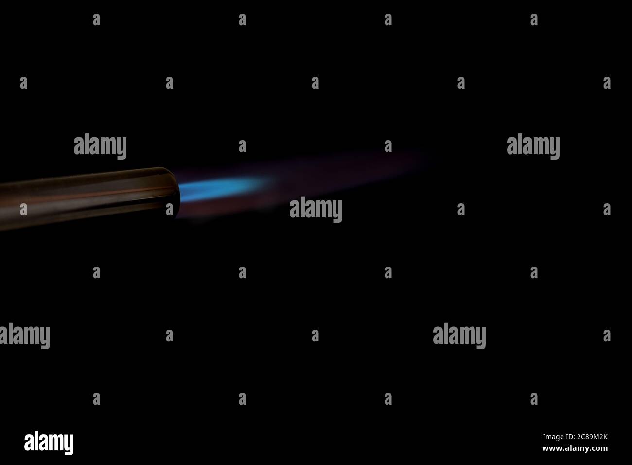 Bruciatore a gas con fiamma blu su fondo nero Foto Stock