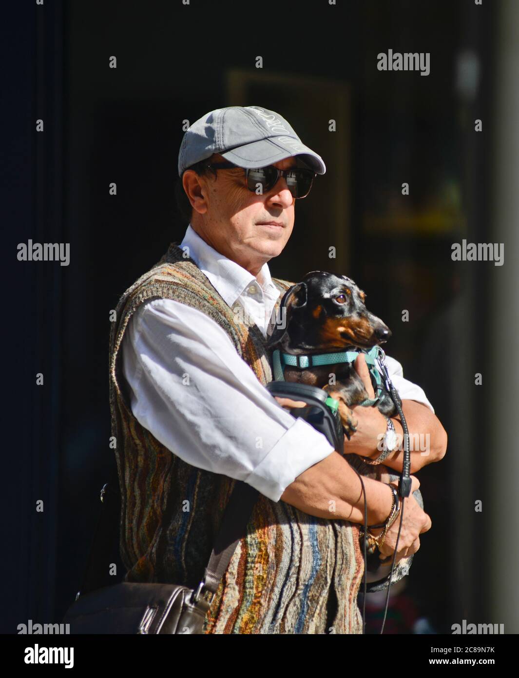 Uomo italiano che porta il suo cane dachshund in Via Sparano da Bari, Bari, Italia Foto Stock