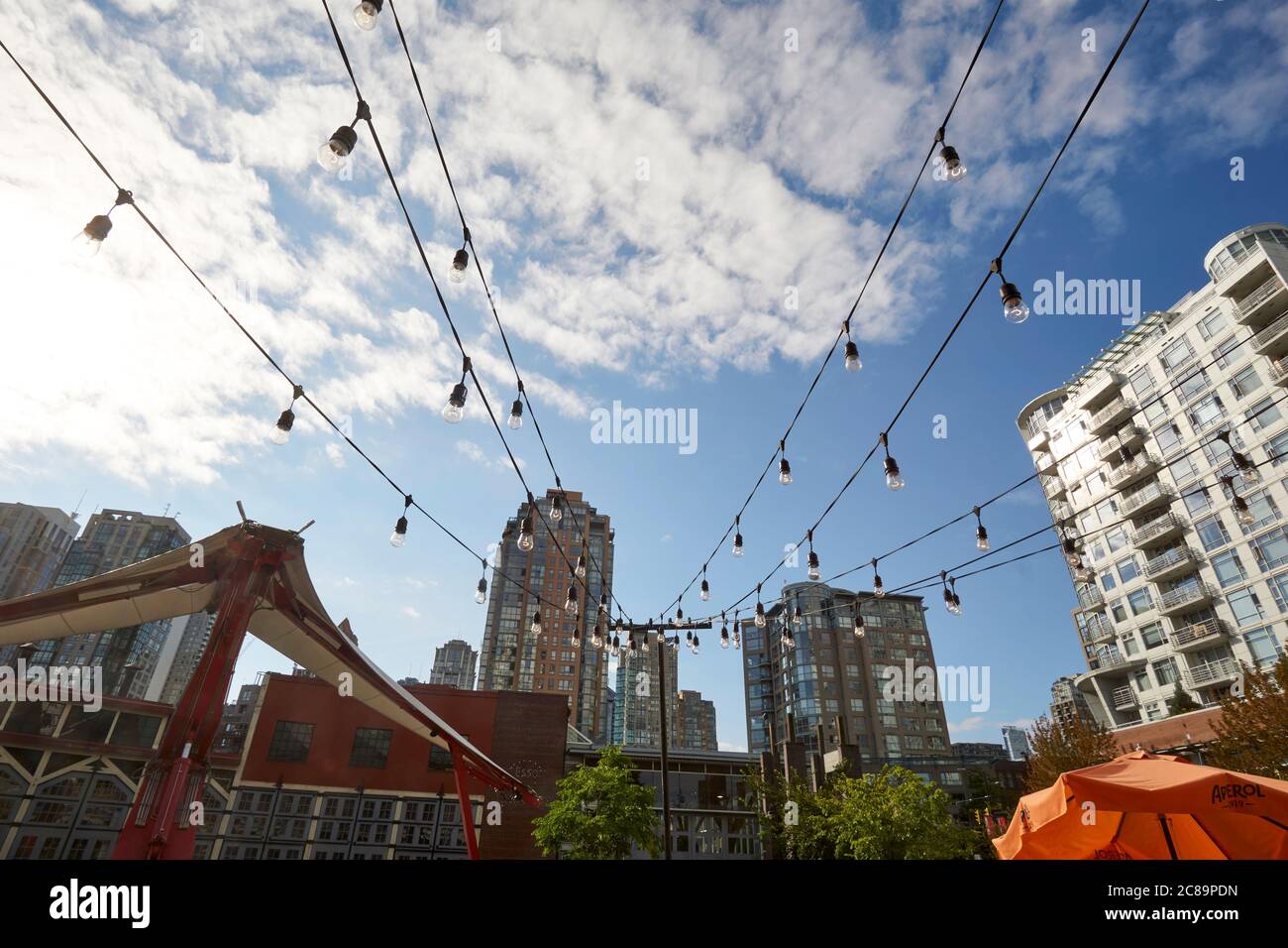 Luci elettriche a soffitto, torri residenziali e gru idraulica nel Roundhouse Turntable Plaza a Yaletown, Vancouver, British Columbia, Canada Foto Stock