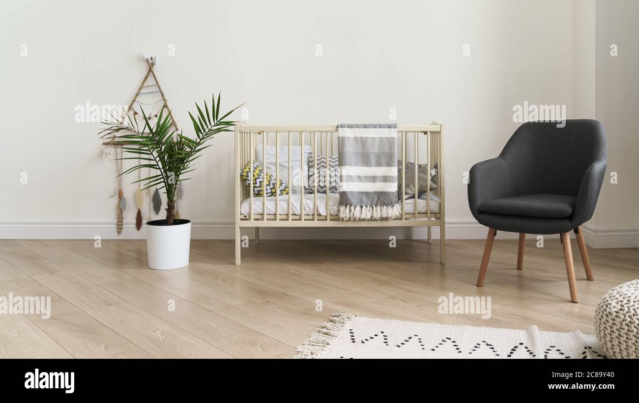 Lettino e moderna sedia grigia e pianta interna nella camera da letto per  bambini Foto stock - Alamy