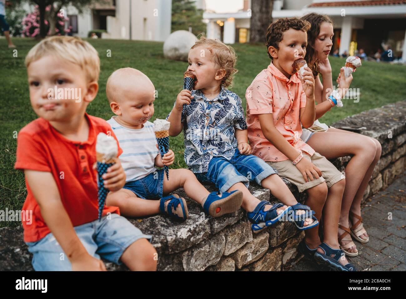 Ragazzi e ragazze mangiano insieme gelato durante le vacanze estive Foto Stock