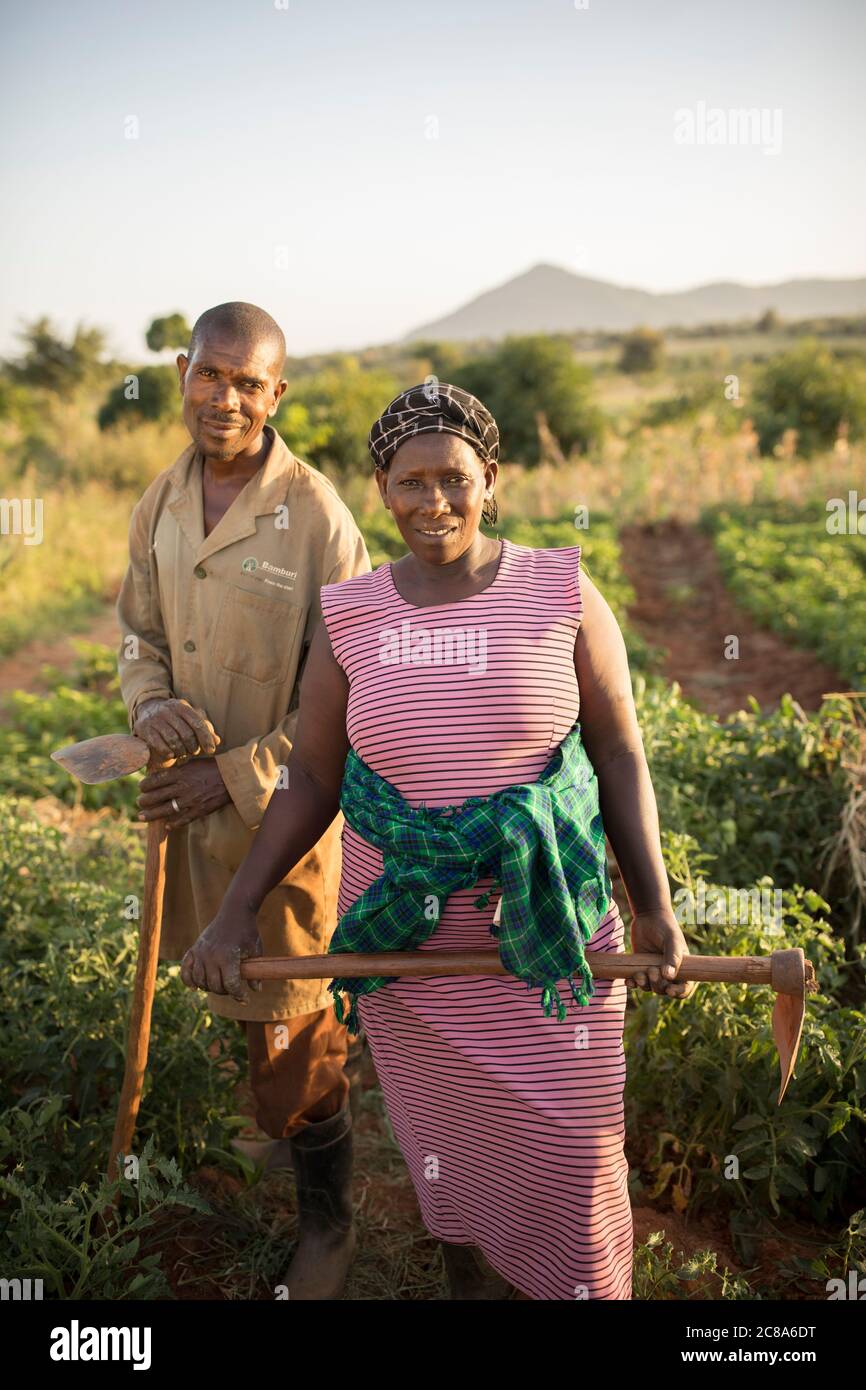 Una moglie e un marito stanno insieme tenendo le zanche nella loro fattoria nella contea di Makueni, Kenya, Africa. Foto Stock