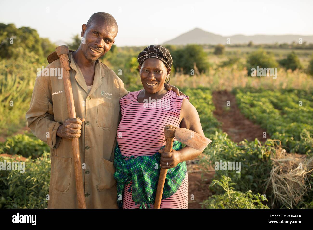 Una moglie e un marito stanno insieme tenendo le zanche nella loro fattoria nella contea di Makueni, Kenya, Africa. Foto Stock