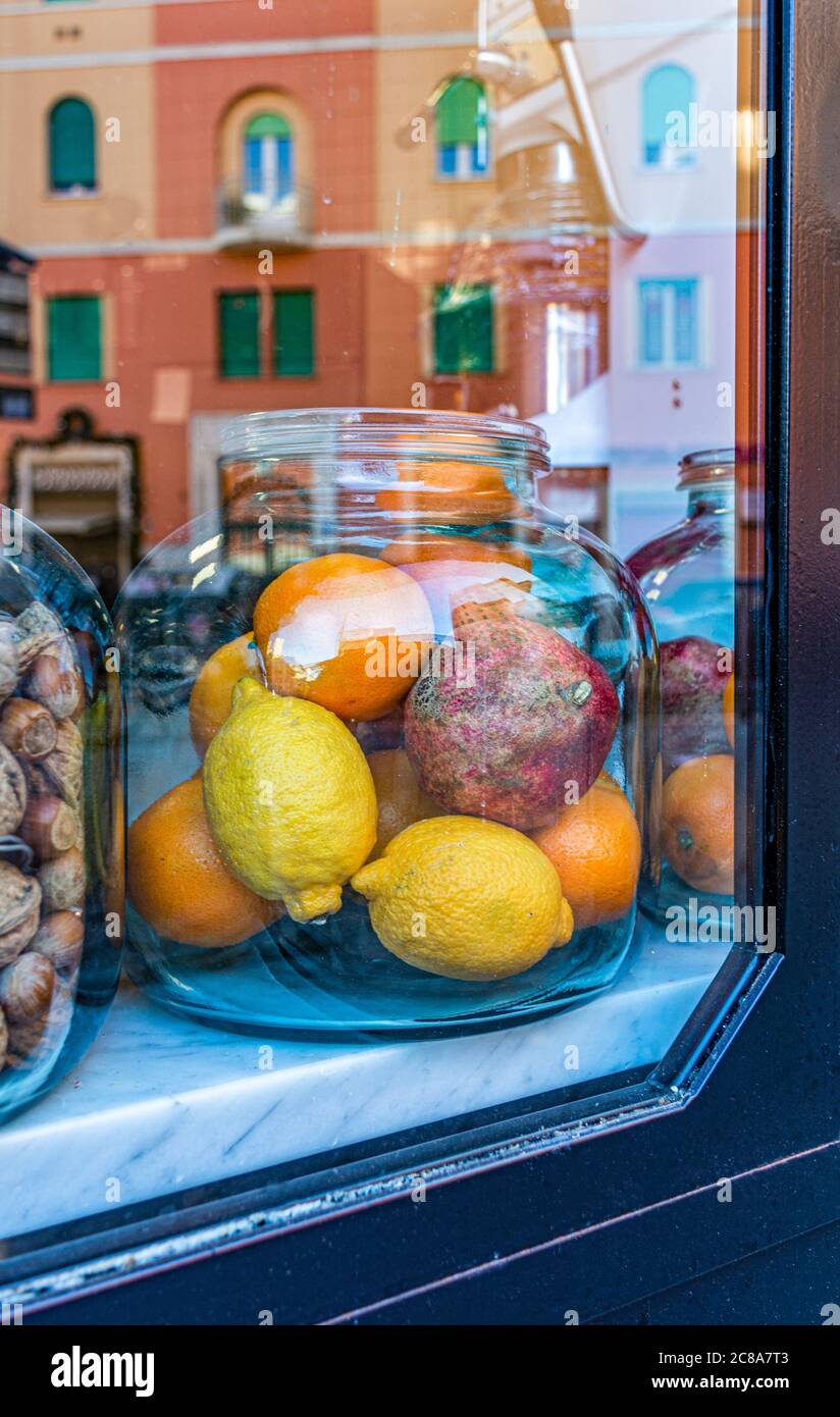 vaso di vetro con frutta biologica sul vetrin del negozio. limone biologico, melograno, arancia in un vaso di vetro Foto Stock