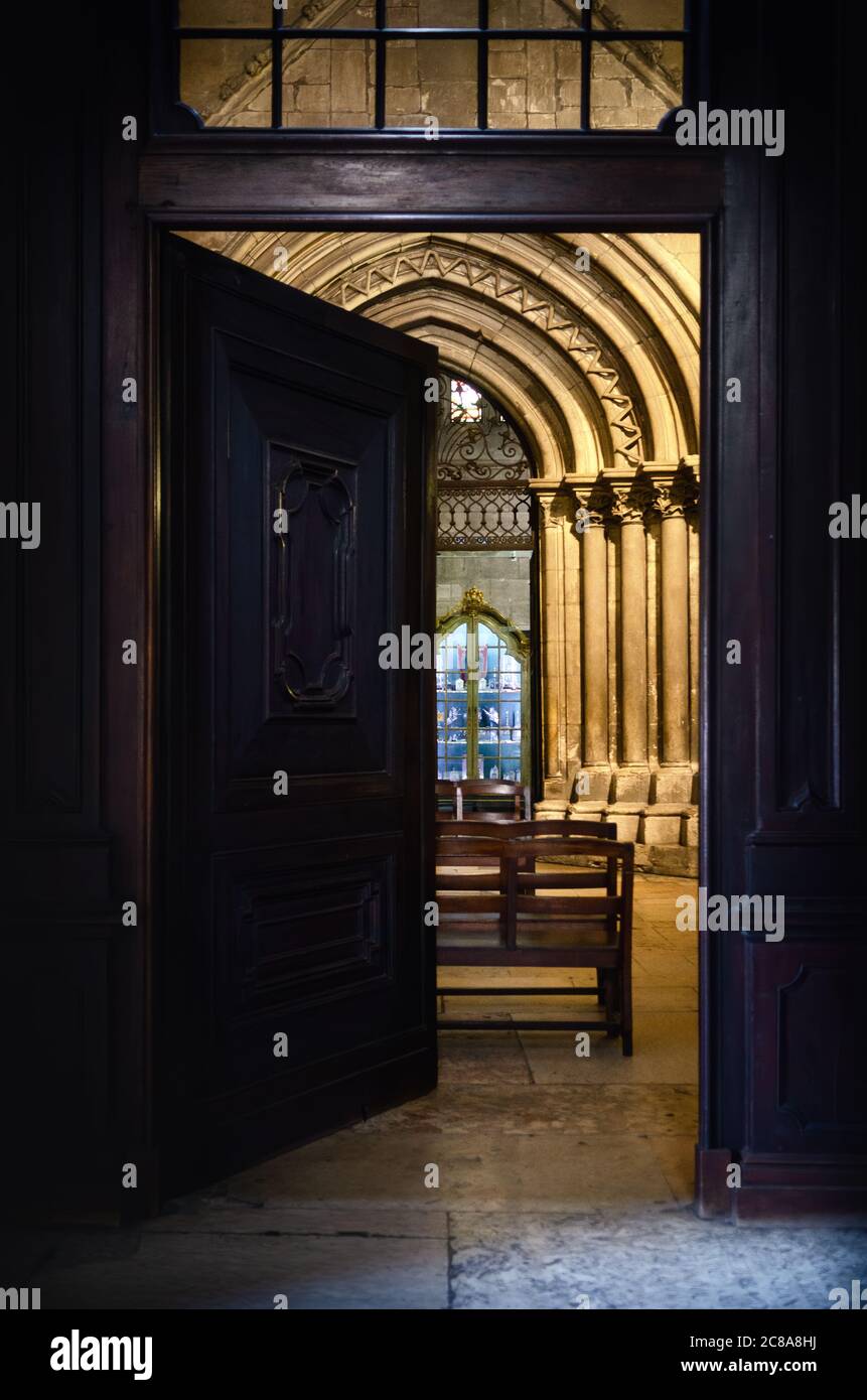 Ingresso porta in legno alla cattedrale di Lisbona, Portogallo. La porta esterna si apre alla navata sinistra dell'antica chiesa gotica Foto Stock
