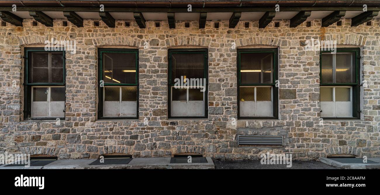 Serie di finestre allineate su un edificio di pietre chiare, architettura di montagna Foto Stock