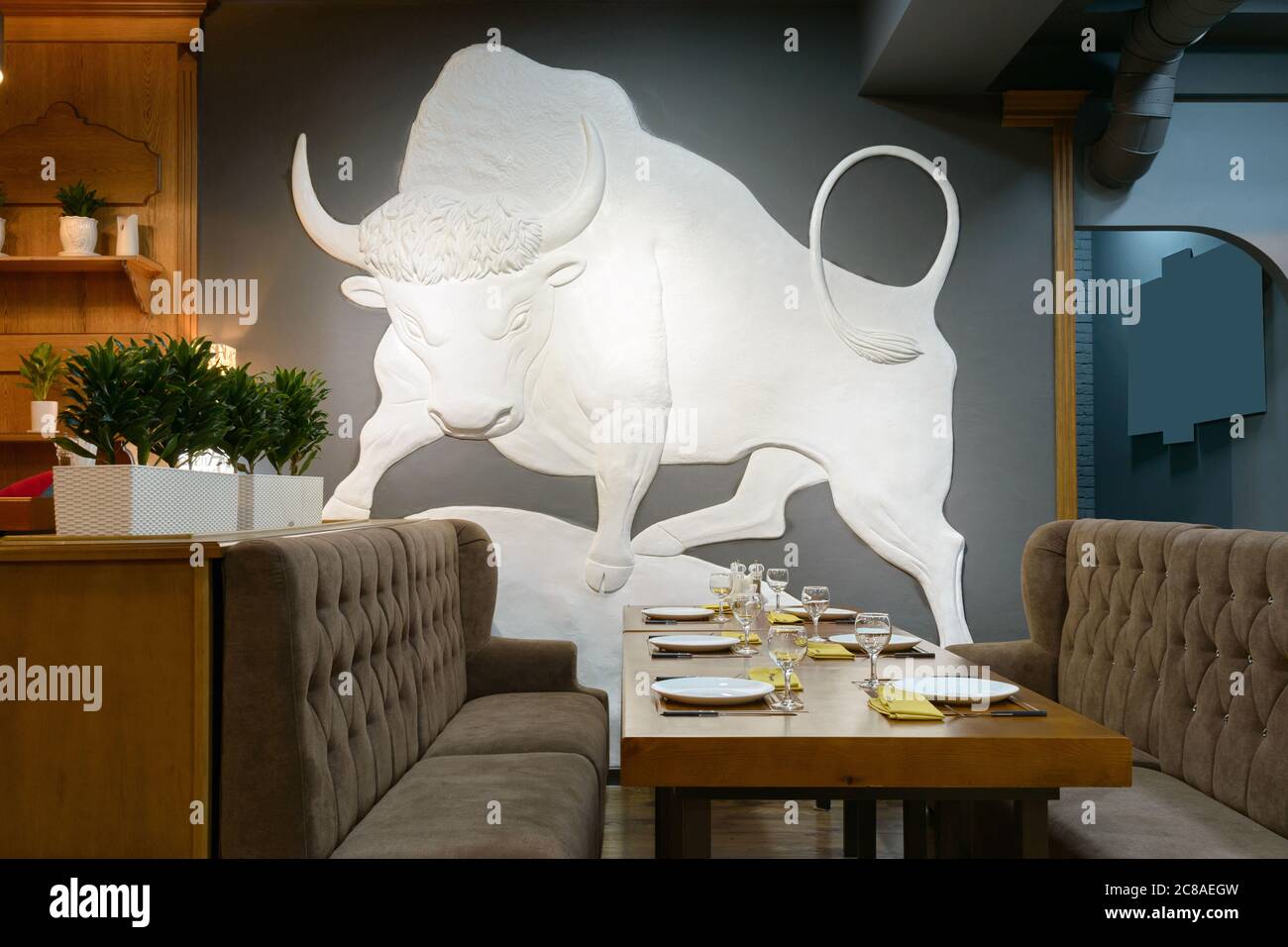 Disegno di un grande toro bianco sulla parete del ristorante nella Steakhouse di fronte al tavolo degli ospiti Foto Stock