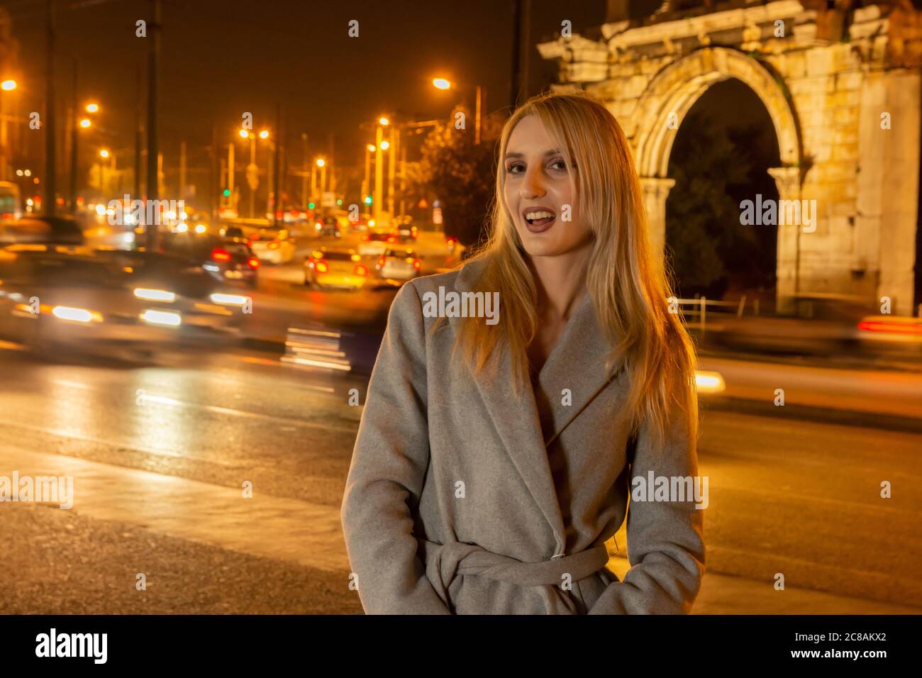 Bella giovane donna in una città di notte di fronte alla porta di mano - vita notturna in un progetto della città Foto Stock