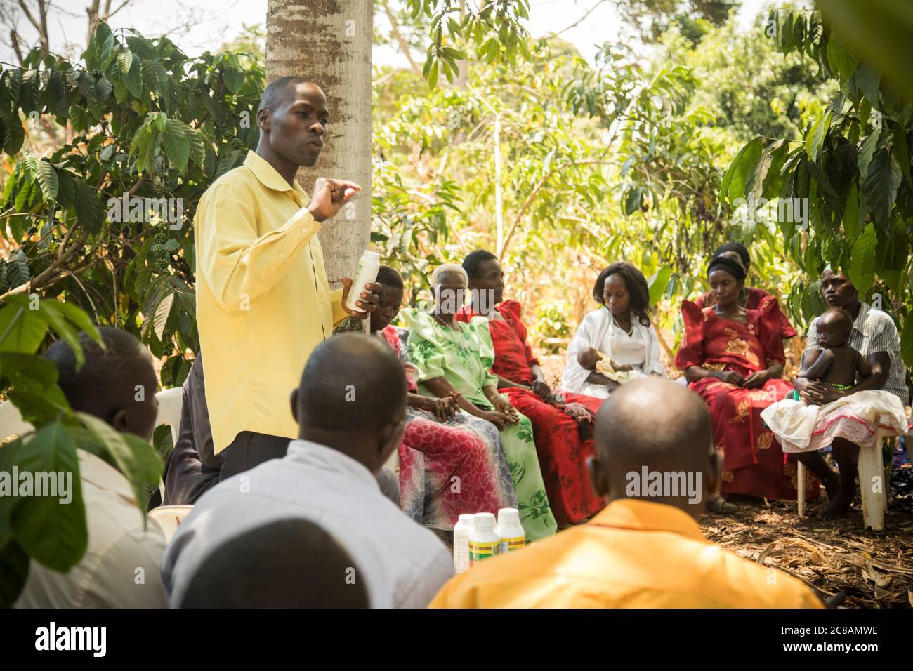 Un lavoratore agricolo di estensione vende i fattori produttivi ai piccoli agricoltori in un villaggio di comunità che si riunisce nel distretto di Masaka, Uganda, Africa orientale. Foto Stock