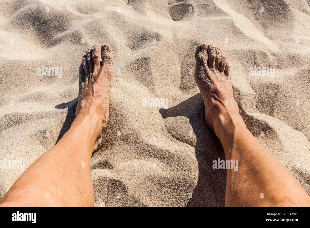 I piedi e le gambe di un uomo che si rilassano su una spiaggia, Messico. Foto Stock