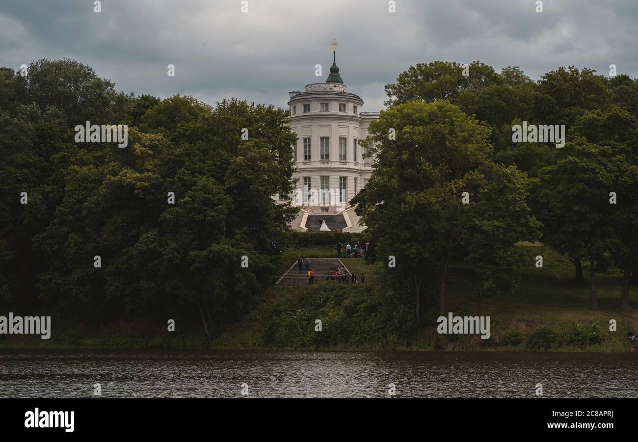 Bellissimo paesaggio di parco con maniero in estate. Pittoresco luogo di Palazzo bianco con laghetto e alberi verdi. Foto Stock