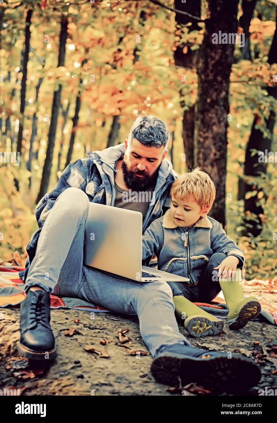 Uniti alla natura. Lezione di ecologia. Scuola forestale e educazione ecologica. L'uomo sopportò padre e figlio piccolo con il laptop nella foresta. Educazione ecologica Foto Stock