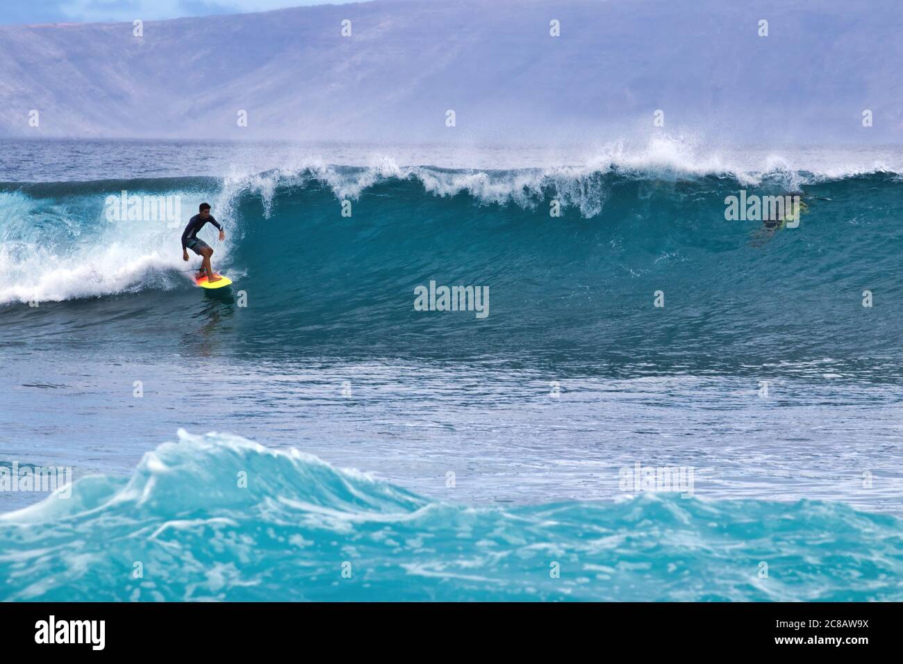 Surfista energico che cavalcano una grande onda sul lato sud di Maui. Foto Stock