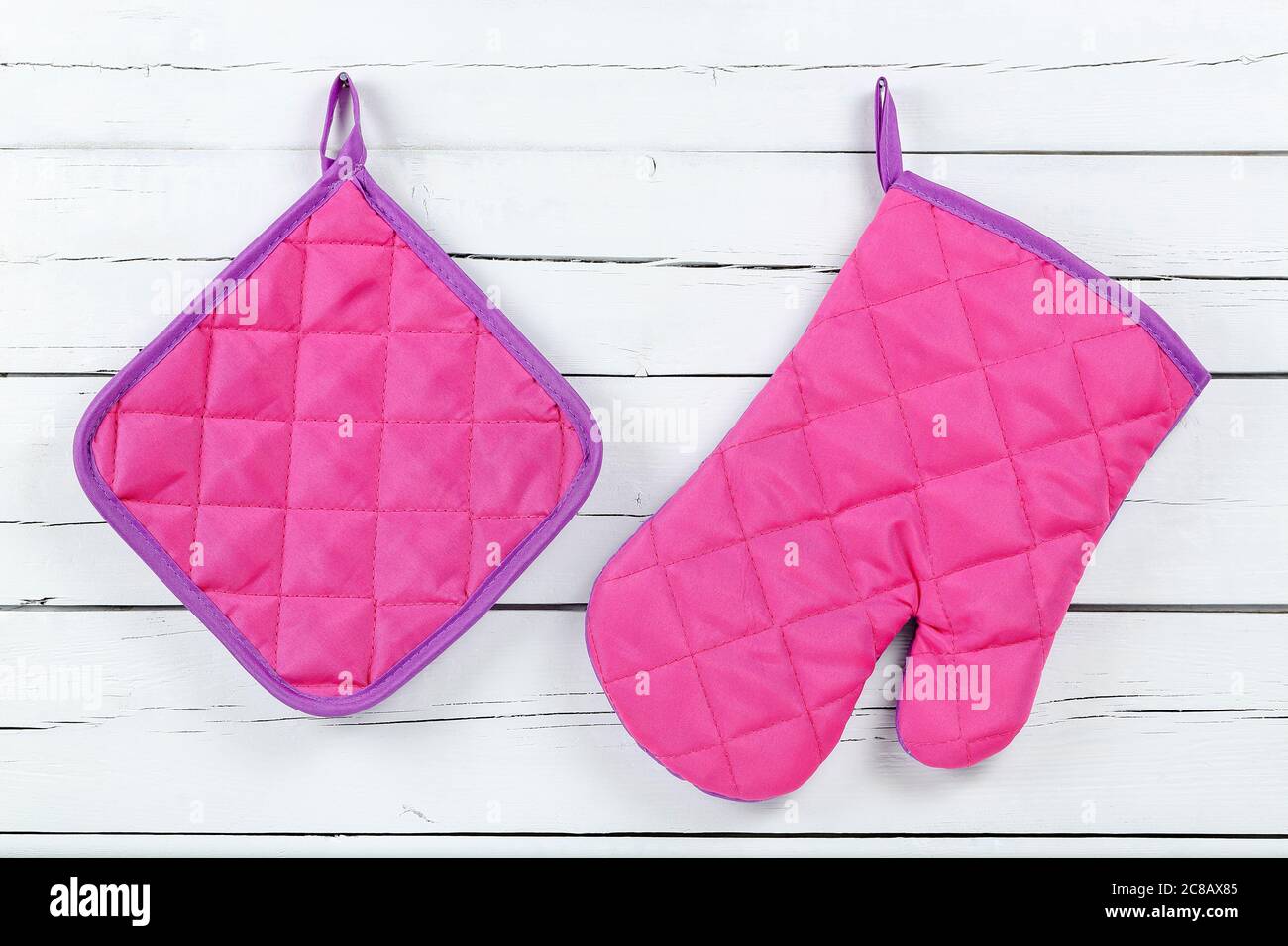 guanto da cucina e porta vasetto su tavole di legno bianche Foto Stock