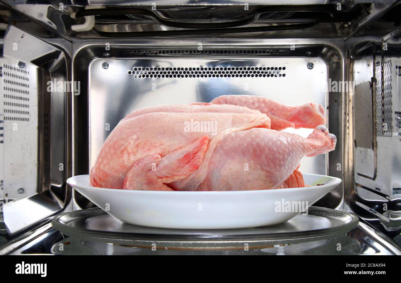 scongelamento del pollo con forno a microonde Foto Stock