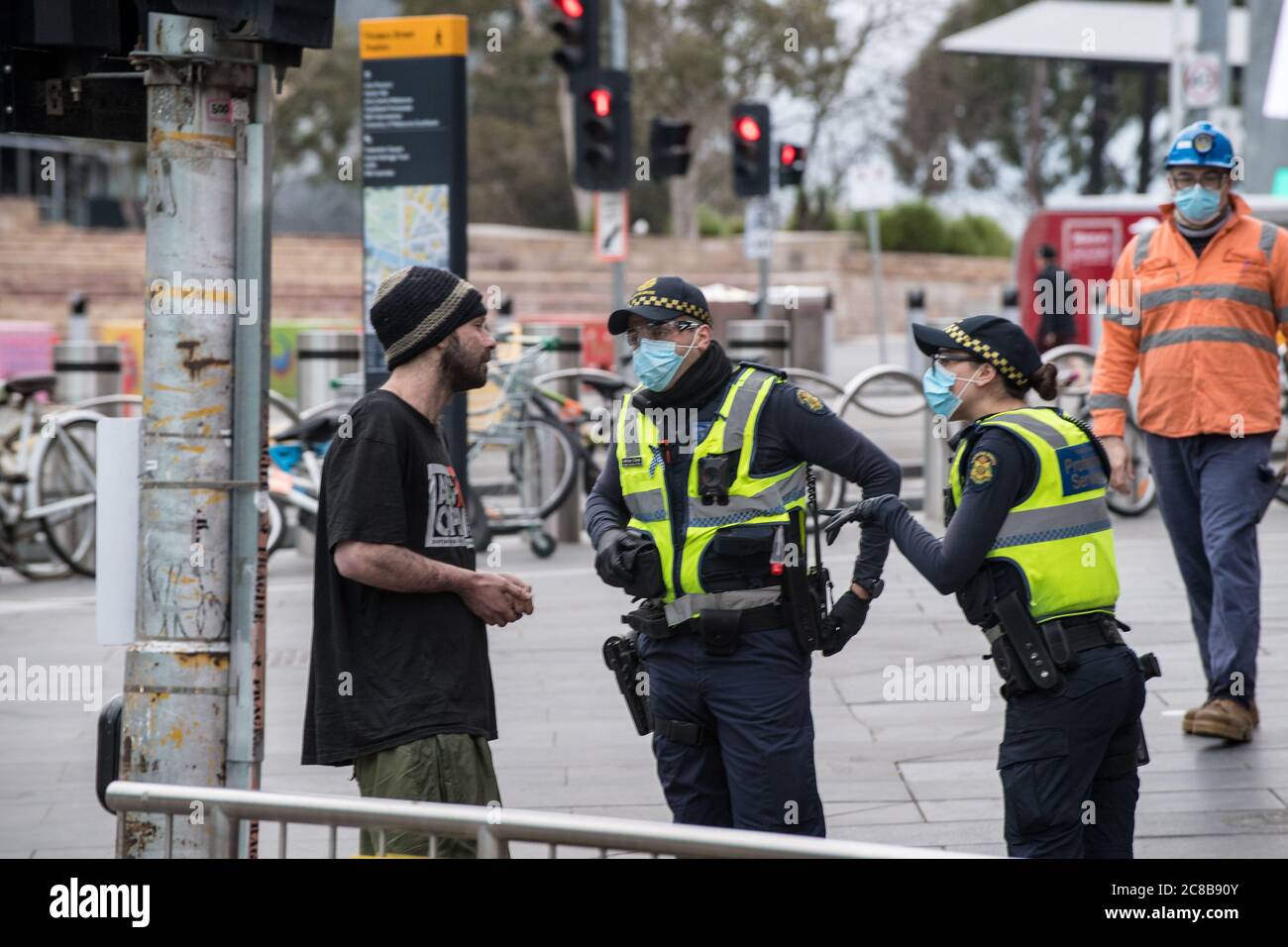 Melbourne, Australia 23 luglio 2020, i funzionari del Servizio di protezione Vittoriano hanno fatto una domanda a un uomo per non avere una maschera alla Flinders Street Station per far rispettare le leggi obbligatorie sulle maschere che iniziano oggi nel tentativo di controllare le pause di Covid-19 nella seconda città australiana più popolosa. Credit: Michael Currie/Alamy Live News Foto Stock