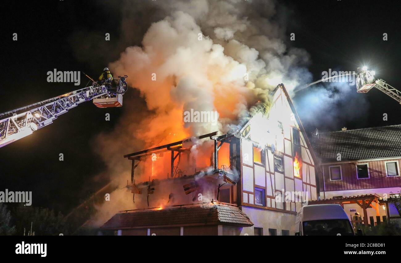 Ehingen, Germania. 23 luglio 2020. Al mattino presto, i vigili del fuoco spengono una casa che è sul fuoco. Un uomo morì nel fuoco. Secondo la polizia, la casa era occupata da quattro uomini, tre dei quali sono riusciti a fuggire. Il quarto uomo è stato trovato morto. Credit: Thomas Warnack/dpa/Alamy Live News Foto Stock