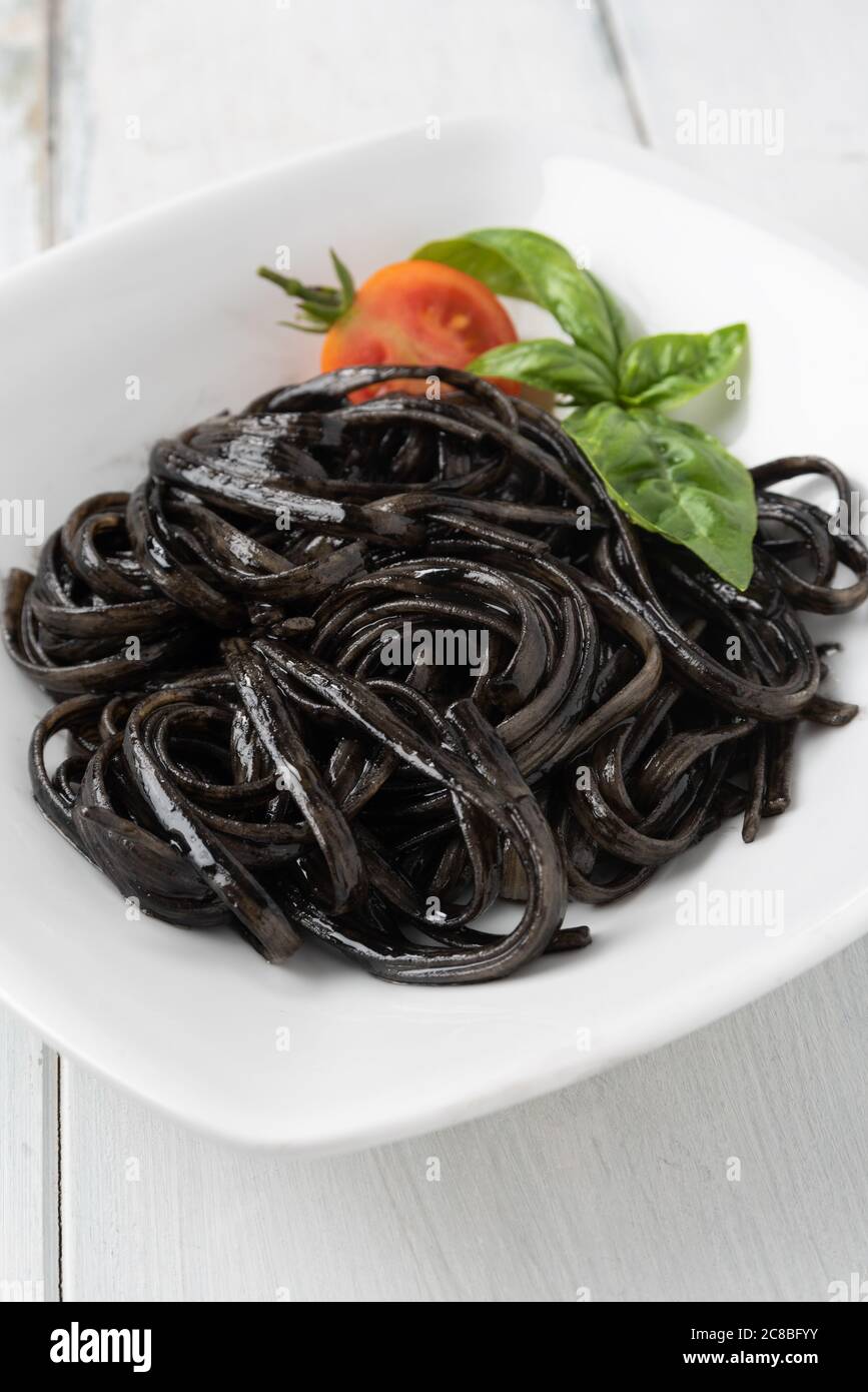 Piatto di deliziosa linguine con salsa d'inchiostro calamaro, una ricetta tipica della pasta italiana Foto Stock